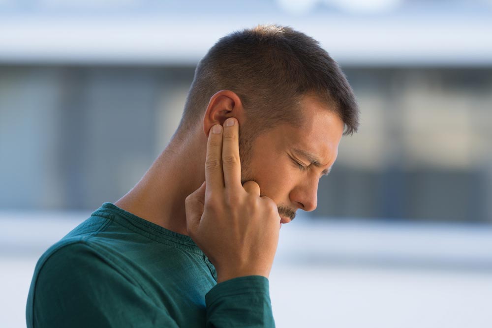 Man touching his ear because of ear pain